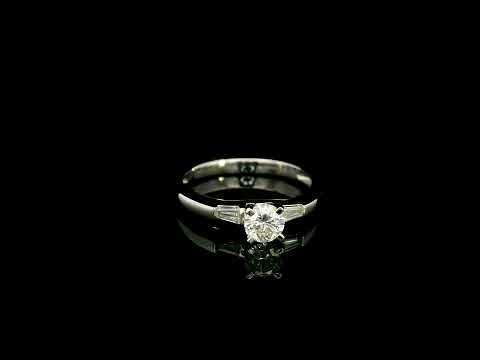 18K white gold round diamond solitaire ring with tapered baguette side diamonds and a classic elegant design.