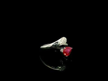 Pear shaped ruby and diamond bypass ring in 18K white gold with open teardrop design