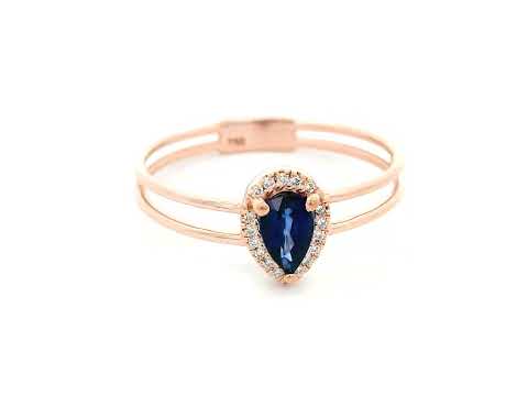 Elegant pear-shaped sapphire and diamond halo ring in 18K gold, featuring a 0.51-carat sapphire and 0.05-carat diamonds in a modern double-band design.