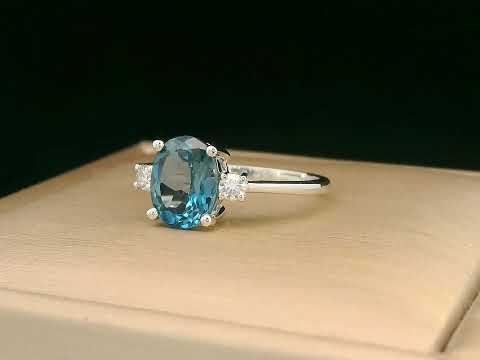 18K white gold ring with side diamonds and blue topaz