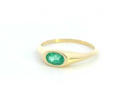 18K yellow gold ring featuring a 0.44-carat oval-shaped emerald in a bezel setting.