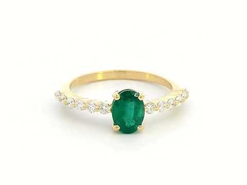 18K yellow gold ring with oval-cut emerald center and round diamond accents on the band

