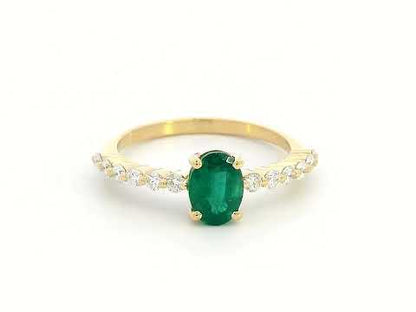 18K yellow gold ring with oval-cut emerald center and round diamond accents on the band

