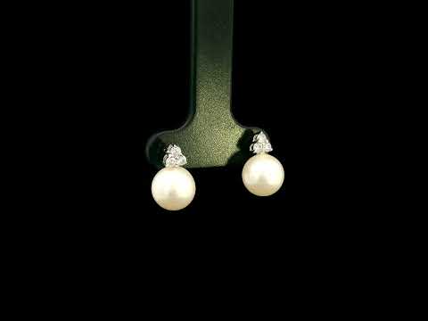 18K white gold freshwater pearl stud earrings featuring 7.5 × 8 mm freshwater pearls with a natural round diamond three-stone cluster and secure butterfly backs.