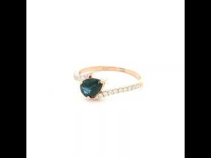 Natural pear-shaped blue sapphire ring in 18K rose gold featuring a 0.78 carat blue sapphire with a bypass diamond band set with 0.19 carat natural diamonds.