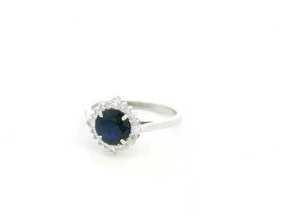 Blue sapphire and diamond halo ring in 18K white gold featuring a 1.24 carat natural blue sapphire and 0.18 carat diamonds