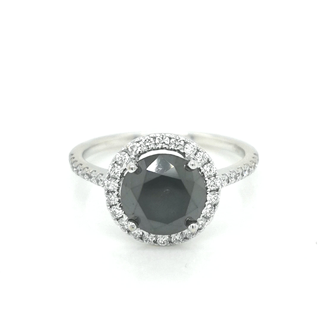 Solitaire Black Diamond Ring With A Diamond Halo In 18k White Gold.