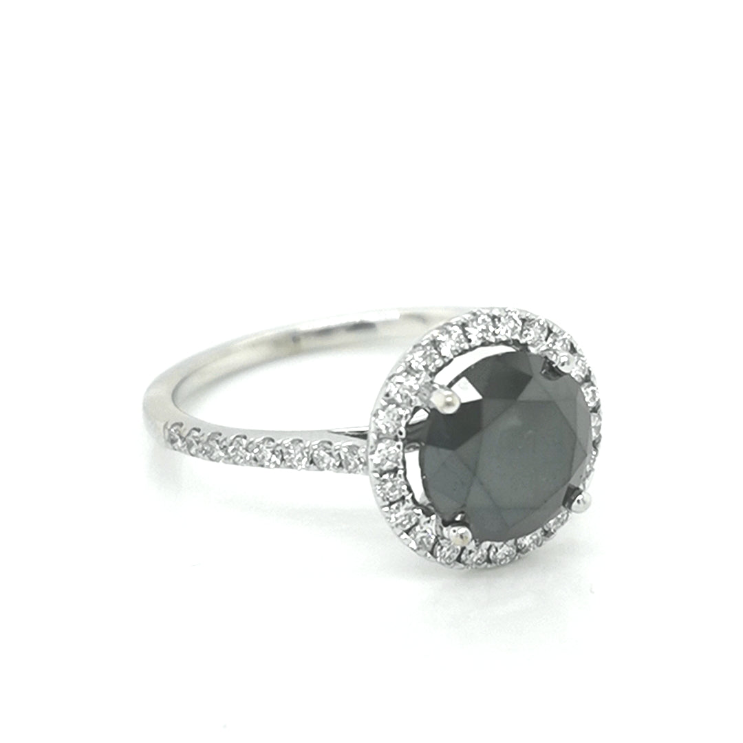 Solitaire Black Diamond Ring With A Diamond Halo In 18k White Gold.