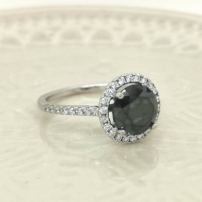 Solitaire Black Diamond Ring With A Diamond Halo In 18k White Gold.