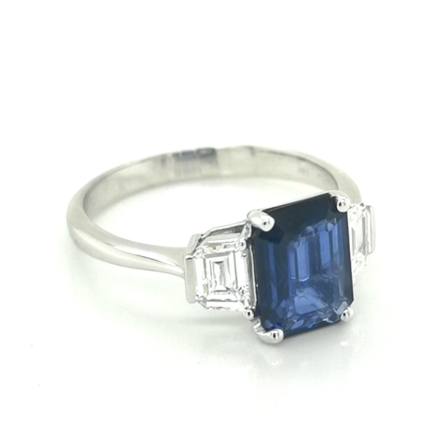 Three Stone Ring-Sapphire With Trapezoid Diamond Side Stone In 18k White Gold.