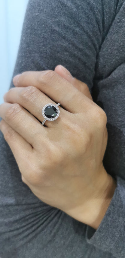 Solitaire Black Diamond Ring With A Diamond Halo In 18k White Gold.
