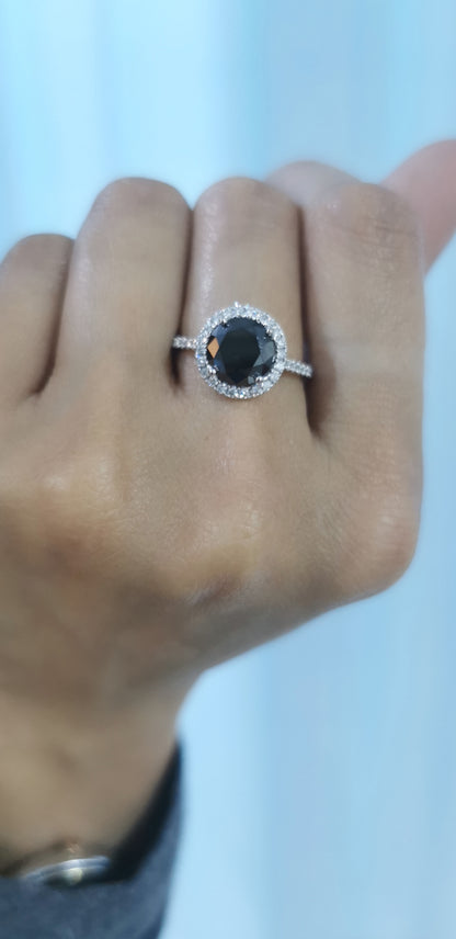 Solitaire Black Diamond Ring With A Diamond Halo In 18k White Gold.