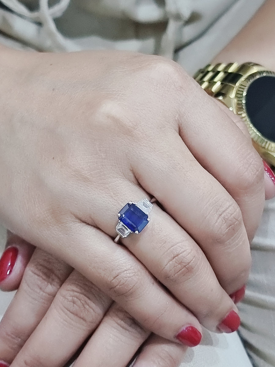 Three Stone Ring-Sapphire With Trapezoid Diamond Side Stone In 18k White Gold.