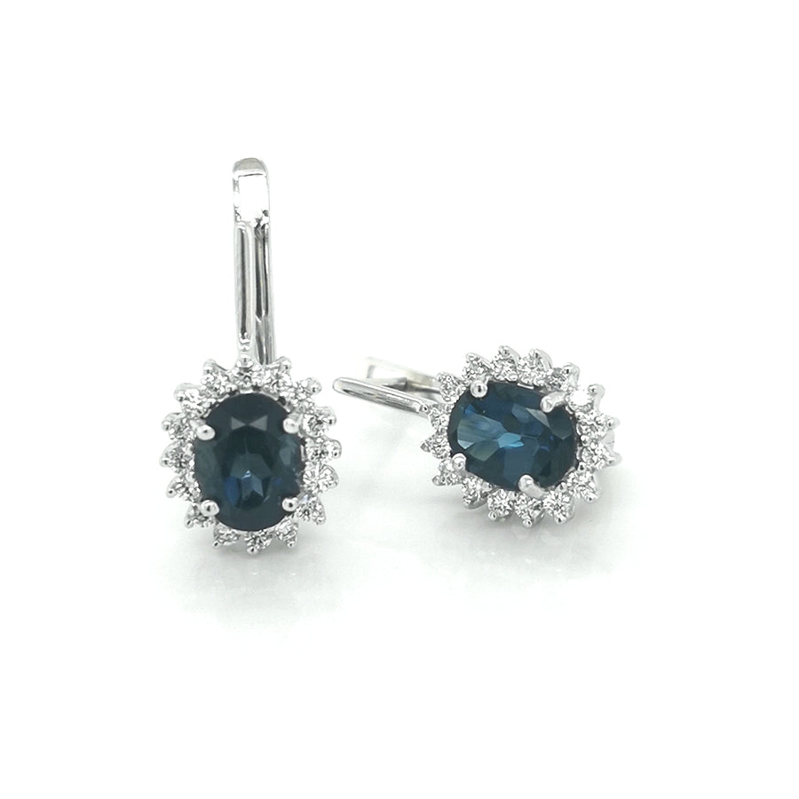 Lovely Blue Tone Of The Oval Shape Vibrant Blue Topaz. Round Cut Diamonds Beautifully Frames The Gemstones. Classy, Elegant And Stylish. This Stunning Combination Of Stones Set In 18K White Gold Is Perfect For Any Occasion, Providing A Sophisticated And Timeless Look That Will Be Cherished For Years To Come.