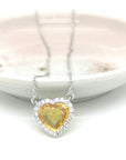 Embrace the warmth of love with this heart-shaped yellow sapphire and diamond pendant, delicately cradled in the embrace of lustrous 18k white gold. The vivid yellow sapphire, a radiant symbol of joy and prosperity, captivates the heart with its enchanting hue, while the surrounding diamonds add a celestial sparkle, making this pendant a true expression of love and elegance that will forever shine brightly close to your heart.
